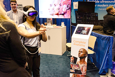 Female attendee trying a medical simulator.
