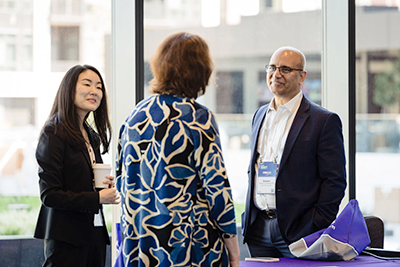 One man and two professionally dressed women conversing.