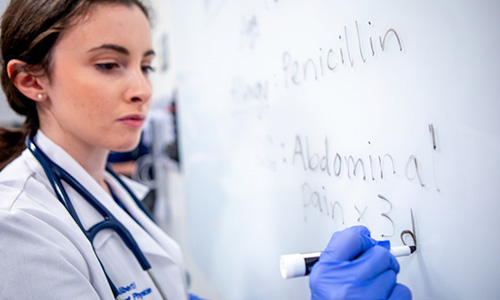 Student doctor doing calculations on a whiteboard