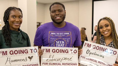 Students holding signs telling where they Matched. 